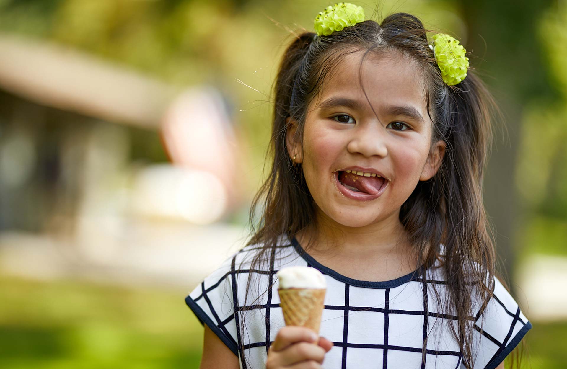 young Hispanic girl smiling eating ice cream cone