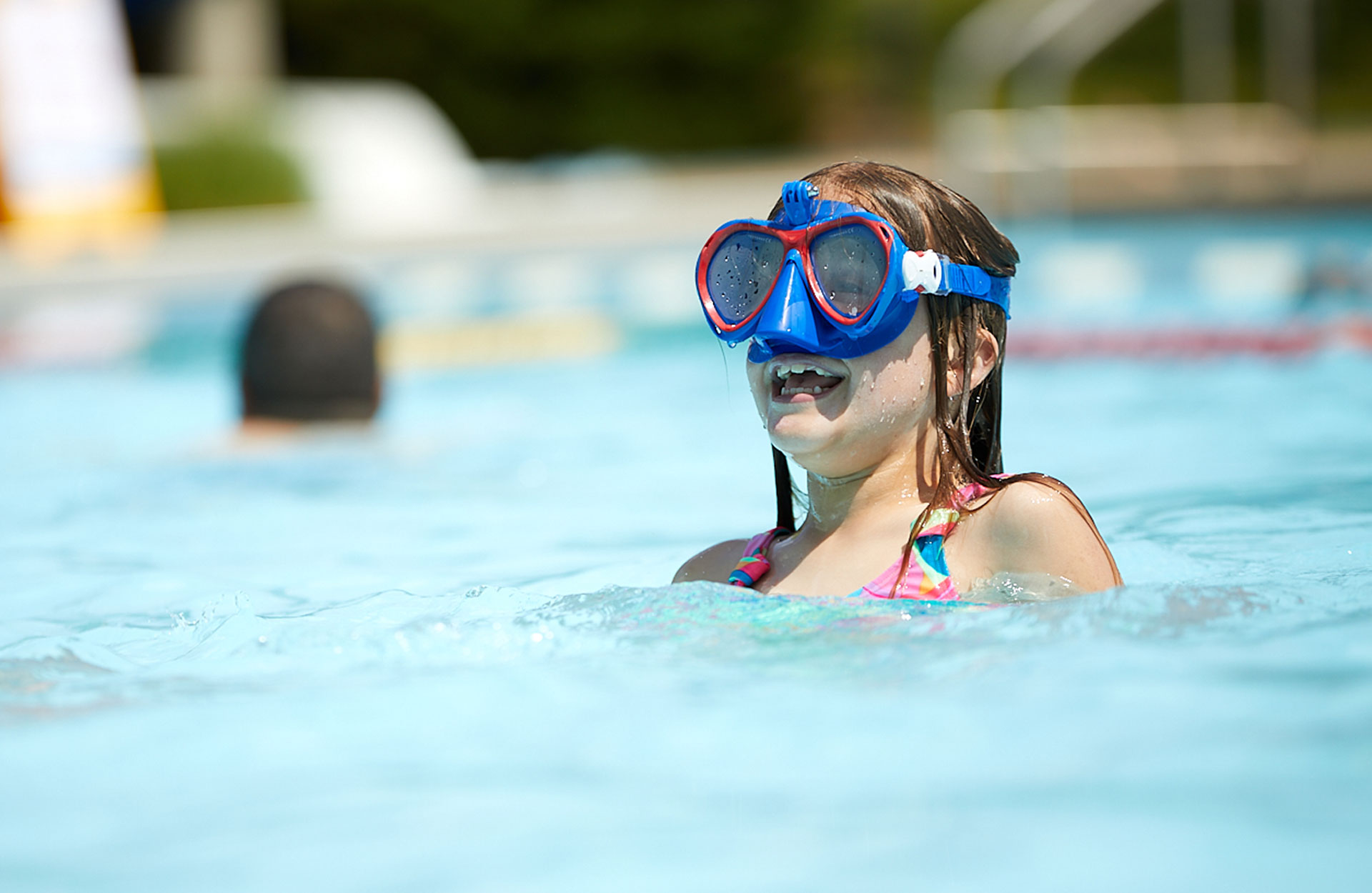 young white girl in pool wearing SCUBA mask