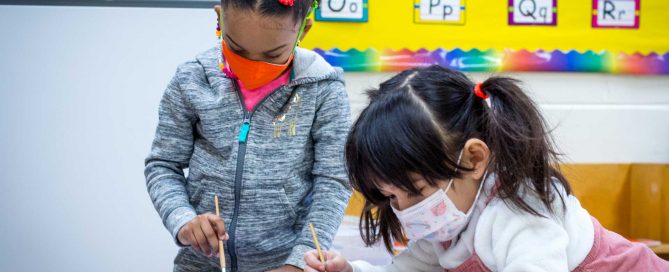 two young girls painting crafts