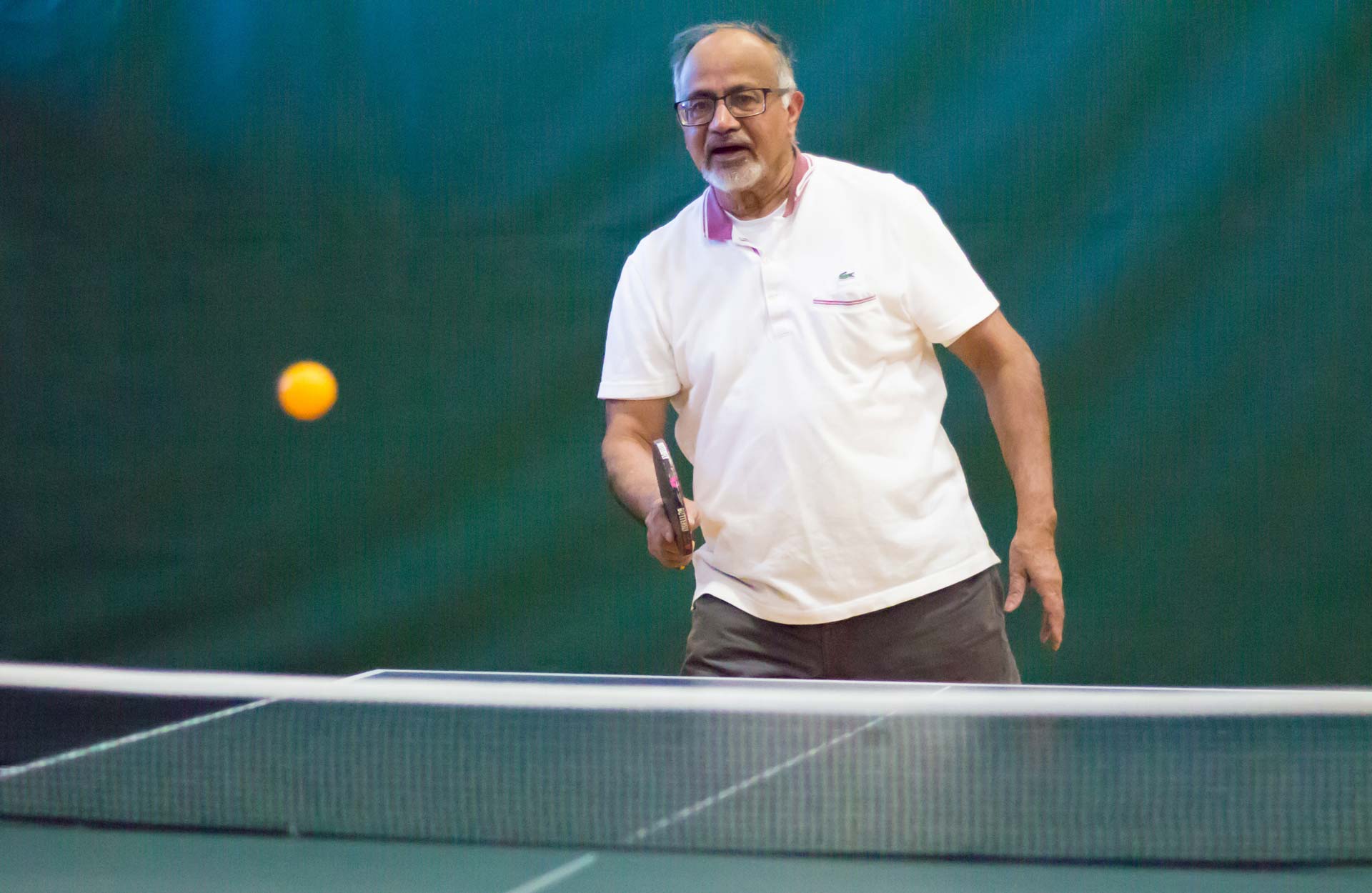 elderly white man playing table tennis