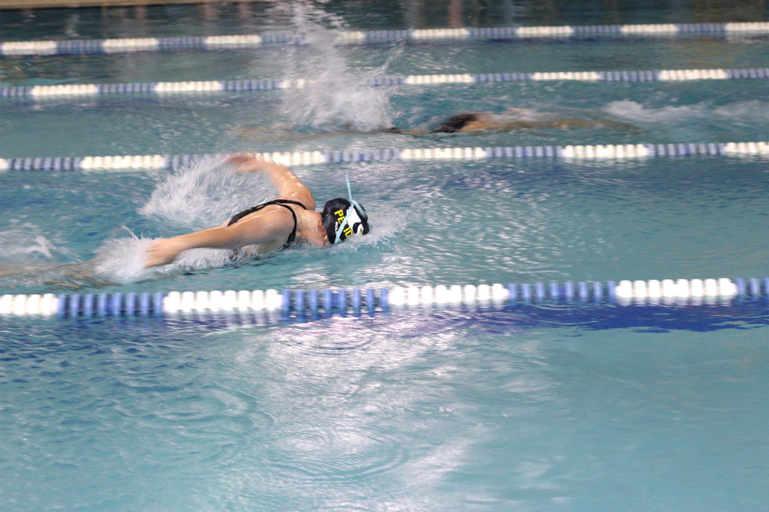 white young adult female doing breast stroke in swimming competition
