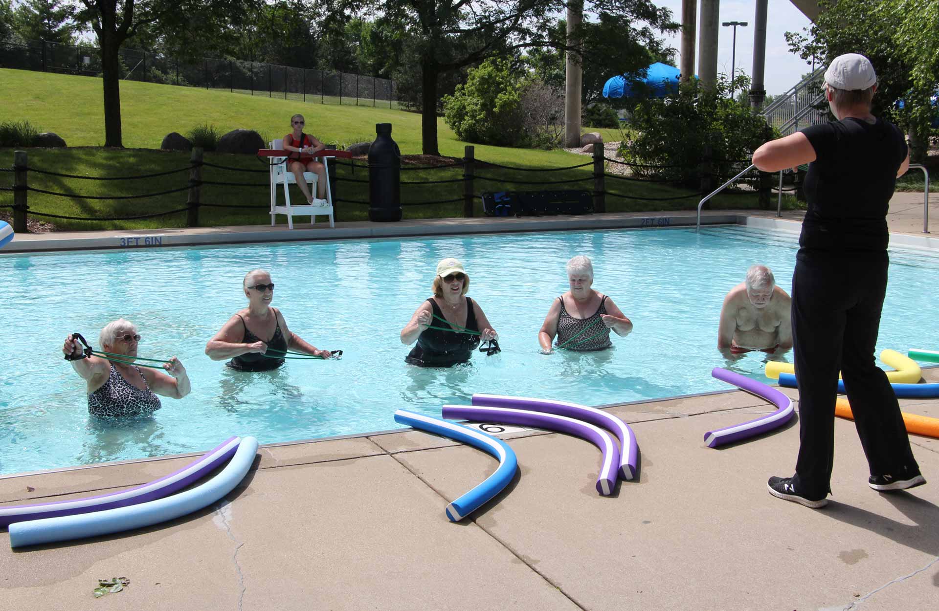 elderly men and women in pool during water aerobics class