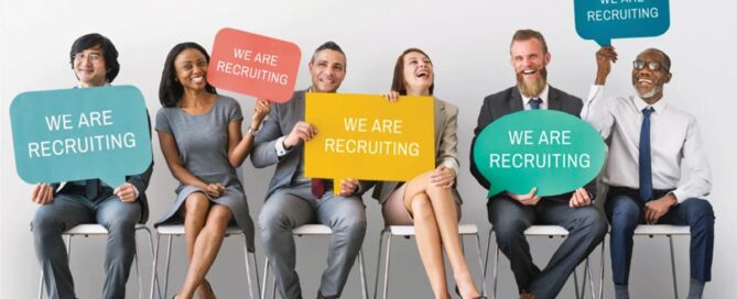 four adult males and two females holding recruitment signs