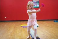 Young Caucasian child dancing with flower