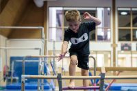 Young Caucasian boy jumping on Ninja obstacle course