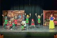 Group of young kids on stage performing a play