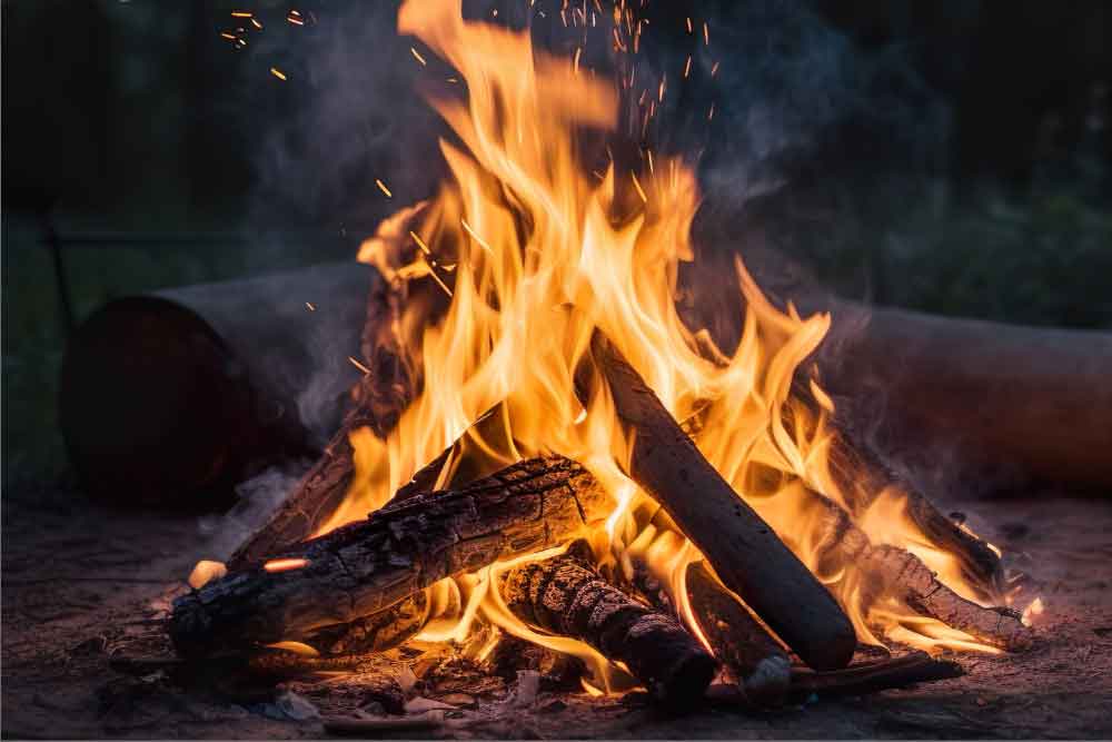 Campfire with orange flames in the night time